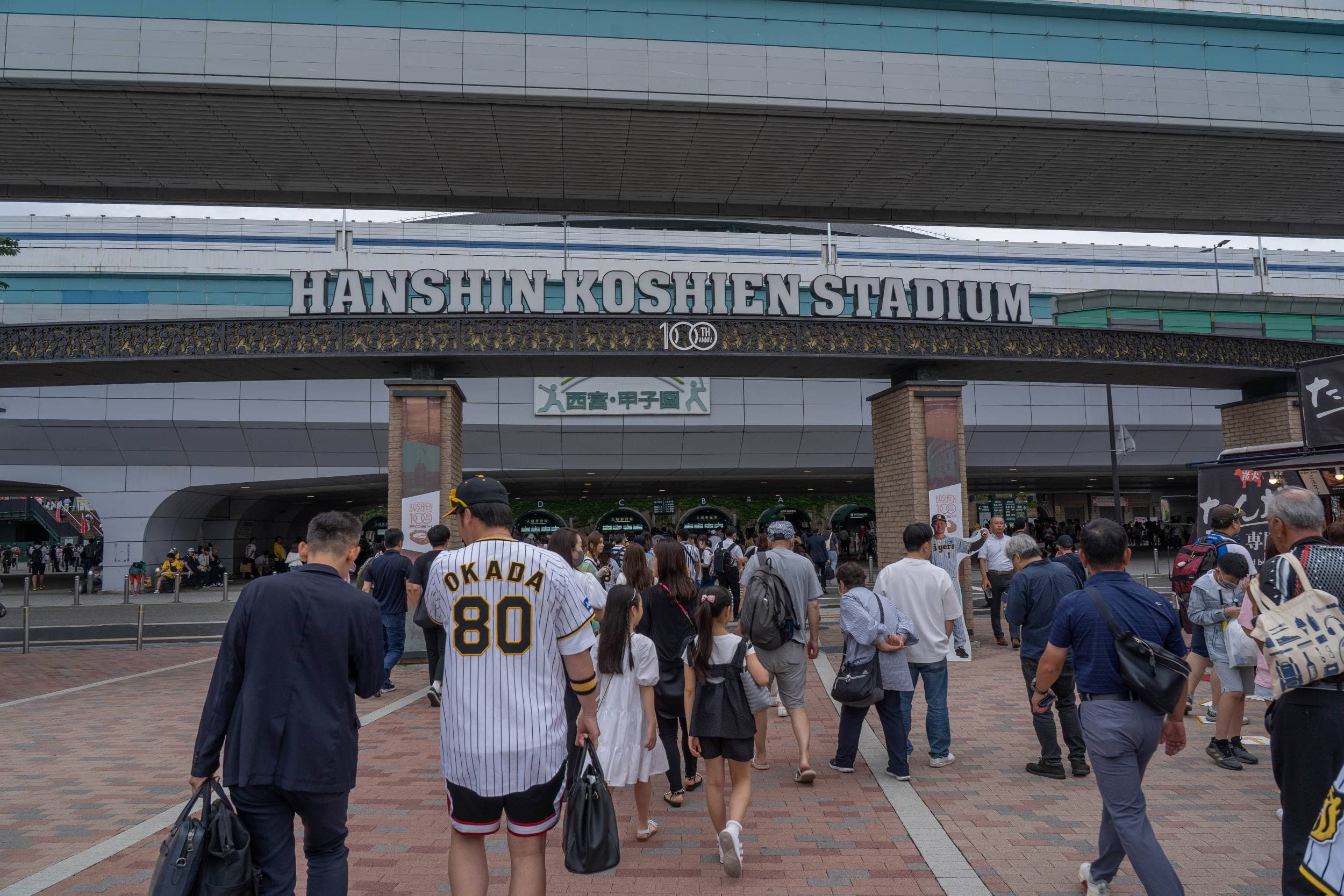Vue large du stade de Koshien : le terrain et les tribunes pendant un match des Hanshin Tigers